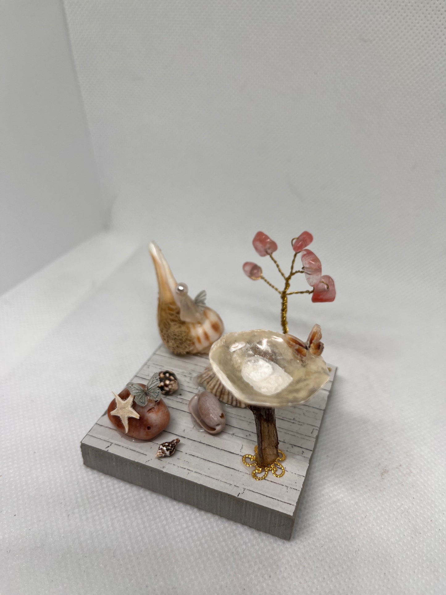 White Sea Glass Fairy Cottage Conch Shell w/ Bird Bath and Watermelon Quartz Tree on Light Tile