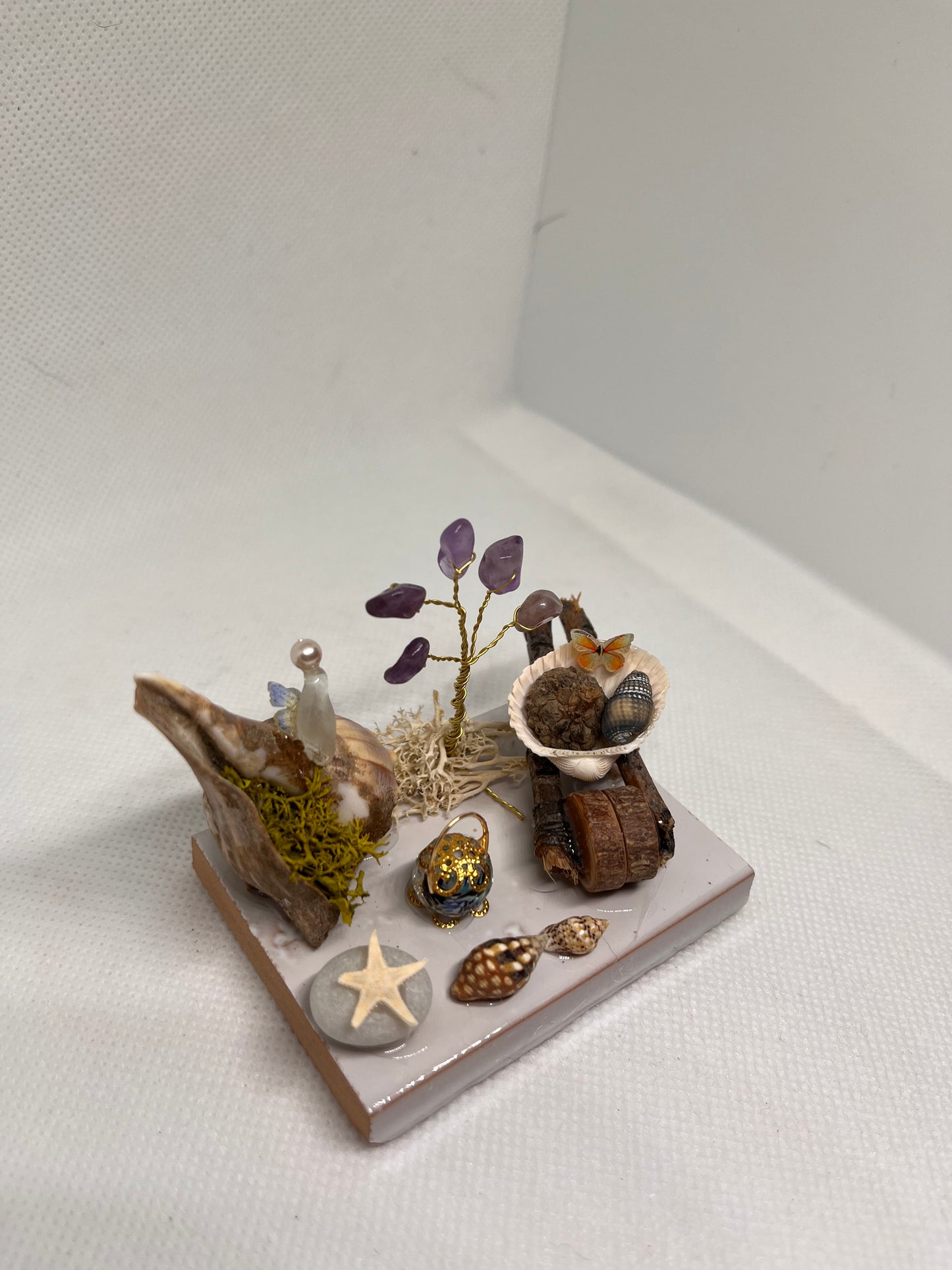 White Sea Glass Fairy Cottage Conch Shell w/ Wheelbarrow, Lantern, and Amethyst Tree on White Tile