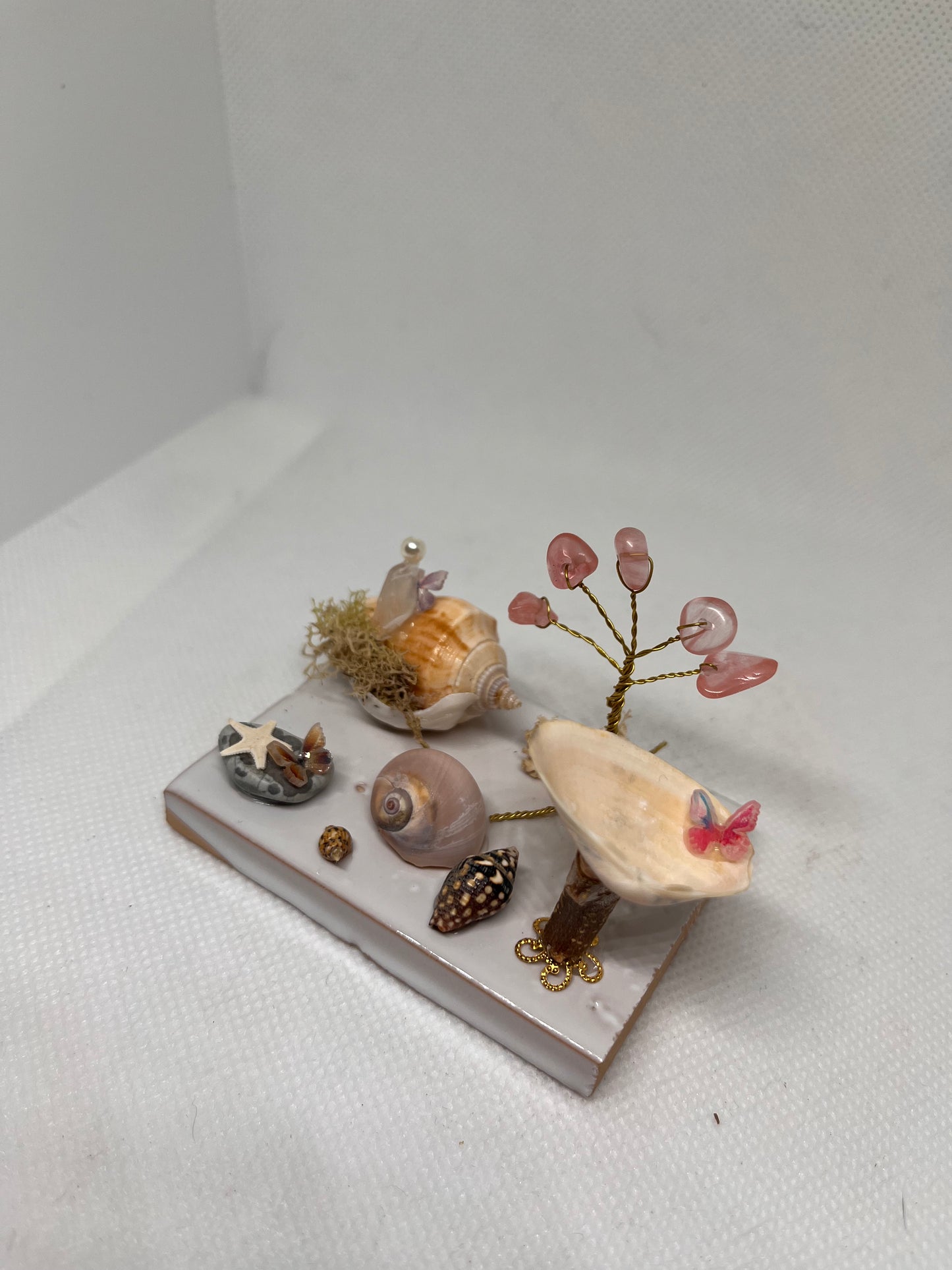 White Sea Glass Fairy Cottage Conch Shell w/ Bird Bath and Watermelon Quartz Tree on White Tile