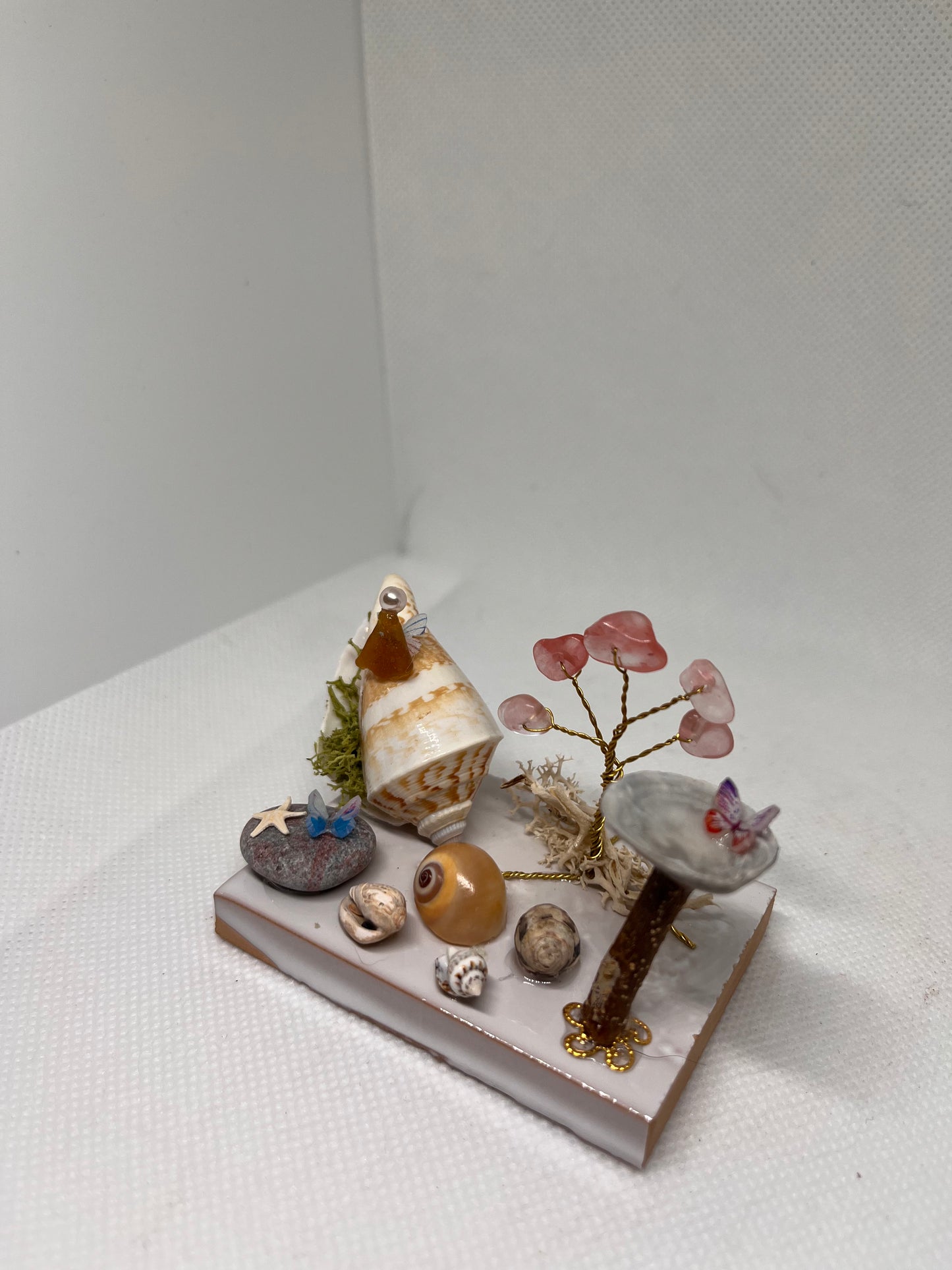 Brown Sea Glass Fairy Cottage Conch Shell w/ Bird Bath and Watermelon Quartz Tree on White Tile