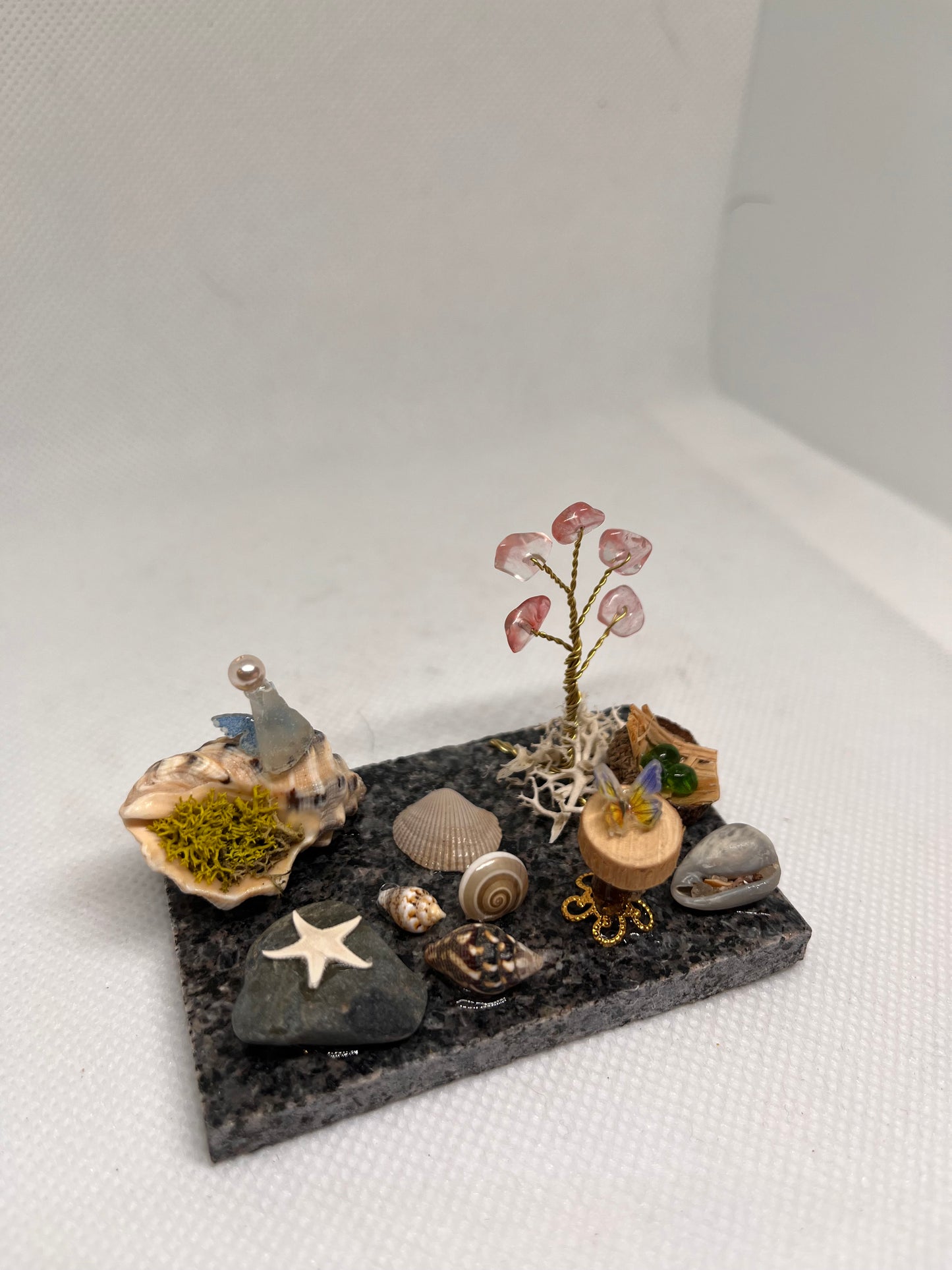 White Sea Glass Fairy Cottage Conch Shell w/ Wood Slice Table, Bird Nest, and Watermelon Quartz Tree on Marble Tile