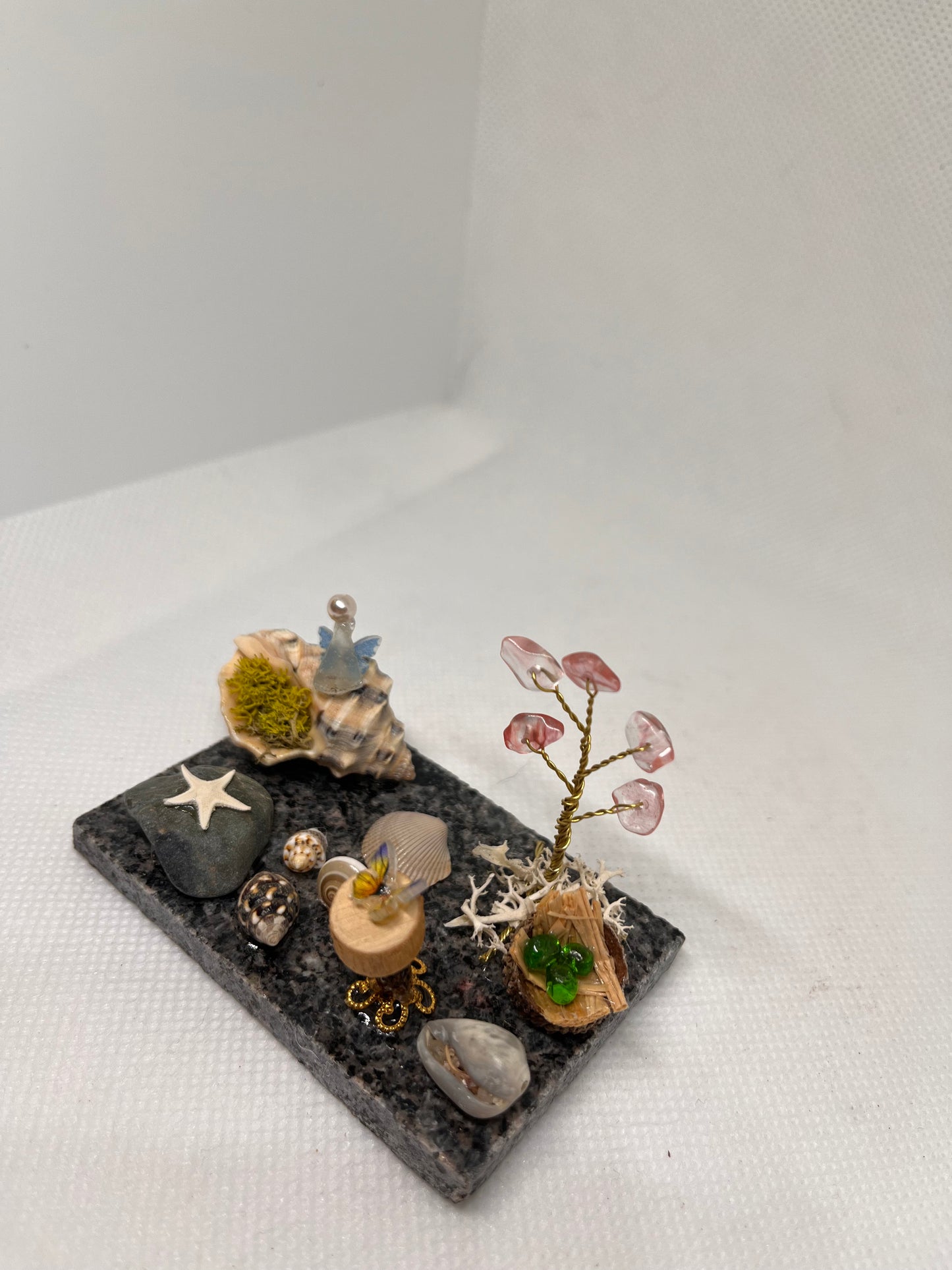 White Sea Glass Fairy Cottage Conch Shell w/ Wood Slice Table, Bird Nest, and Watermelon Quartz Tree on Marble Tile