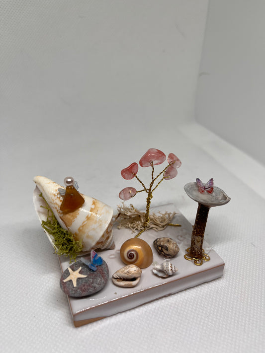Brown Sea Glass Fairy Cottage Conch Shell w/ Bird Bath and Watermelon Quartz Tree on White Tile