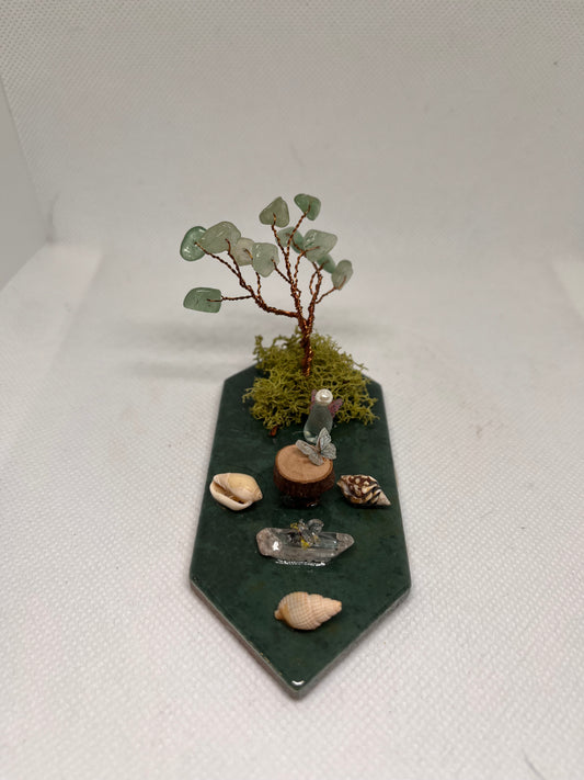 Small White Sea Glass Fairy Cottage Conch Shell w/ Wood Slice Table, Quartz Bench, and Aventurine Tree on Green Tile